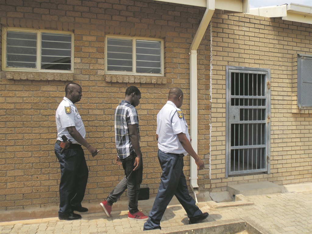 Thabang Ndlovu escorted to the holding cells at Mhala Regional Court on Friday.     Photo by                      Tlangelani Khosa