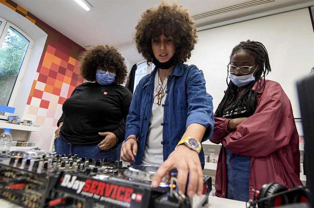 Yasmina Gaida (centre), known professionally as Fouchika Junior, gives a demonstration before students during a DJ mixing class as part of the "DJ Academy for Girls" at the French Institute of Tunisia. In three years, the "DJ Academy for Girls", supported by international foundations, has trained around 100 female DJs. (FETHI BELAID / AFP)
