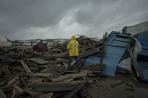 People walk through debris on the streets of the city of Beira, Sofala Province, Mozambique, after Cyclone Idai made land fall. (Josh Estey, CARE via AP)
