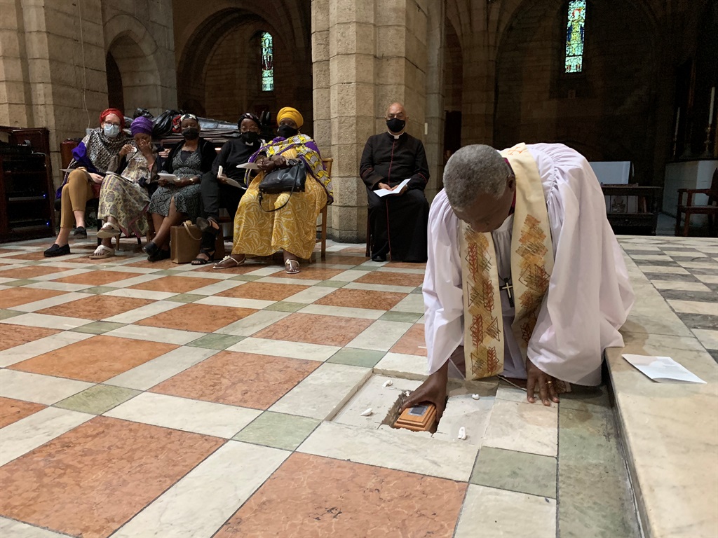 Archbishop Thabo Makgoba lays the ashes of Archbishop Emeritus Desmond Tutu to rest at the high altar of St George's Cathedral, with members of the Tutu family and Dean Michael Weeder of the Cathedral in the background. 