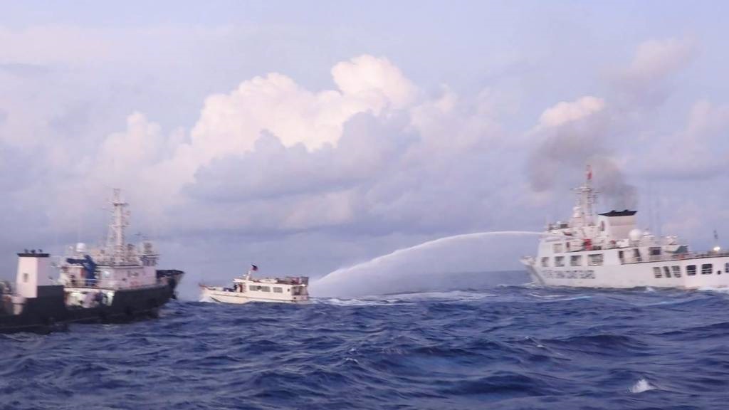This handout photo shows a China Coast Guard vessel (R) using water cannon against the M/L Kalayaan chartered supply boat (C) during a mission to deliver provisions at Second Thomas Shoal in disputed waters of the South China Sea. 