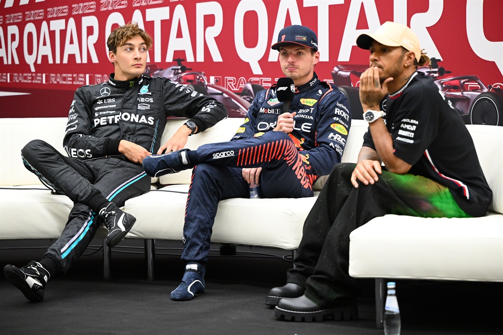 Red Bull's Max Verstappen (centre) is flanked by Mercedes drivers George Russell (left) and Lewis Hamilton (right) during a press conference after qualifying ahead of the F1 Grand Prix in Qatar. 