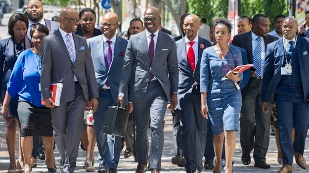 Minister of Finance Malusi Gigaba, flanked by his deputy S'fiso Buthelezi (C-R), South African Revenue Service head Tom Moyane (C-L) and other members of the finance ministry, as they walk towards the National Assembly ahead of the 2018 Budget Speech. (Rodger Bosch, AFP)