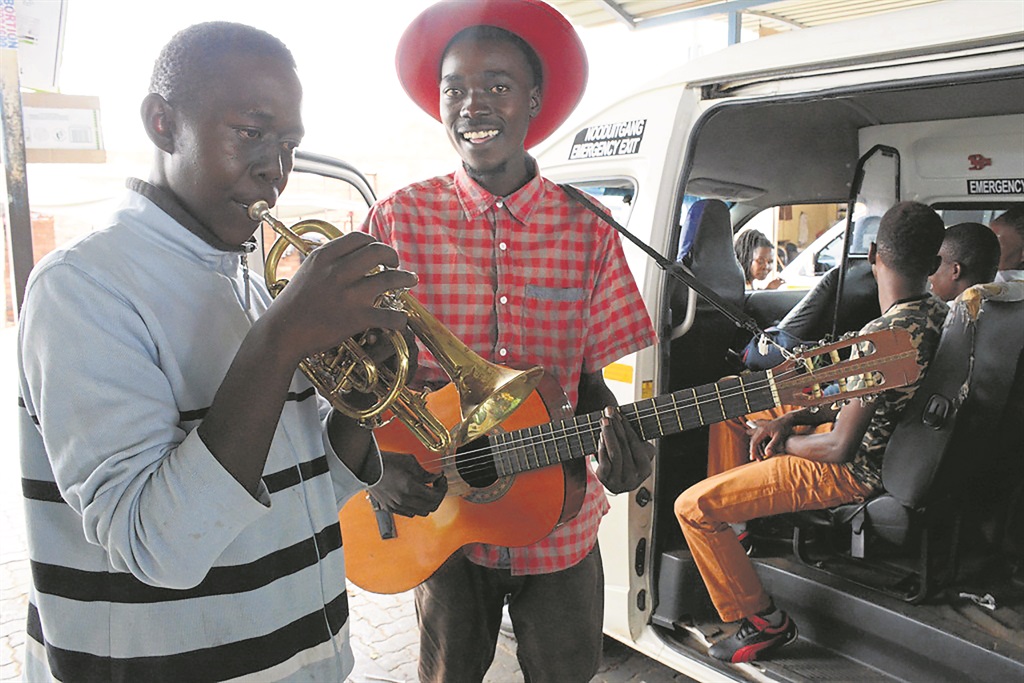 Thabiso Molefe (left) and Emmanuel Mkhwanazi entertain passengers while they wait for taxis to fill up.Photo by Bongani Mthimunye