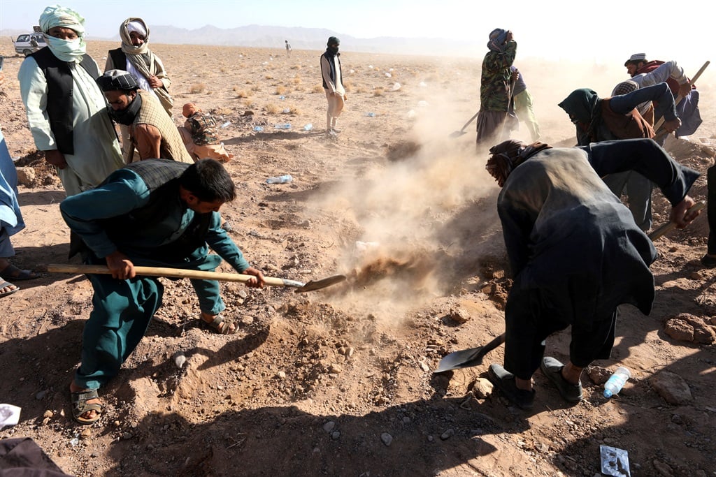 Afghan mourners cover a grave with soil after funeral prayers of victims' bodies from the earthquakes in Kashkak village, Zendeh Jan district of Herat province on October 8, 2023.