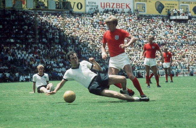 Germany's Franz Beckenbauer (white) with a sliding tackle on England's Colin Bell at the 1970 World Cup (Photo by Mirrorpix via Getty Images)