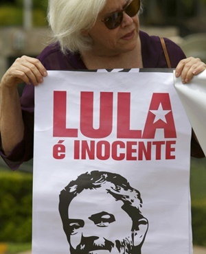 A woman carries a poster that reads in Portuguese "Lula is Innocent," during a protest in support of the Former Brazilian president Luiz Inacio Lula da Silva, in Brasilia, Brazil. (Eraldo Peres, AP)