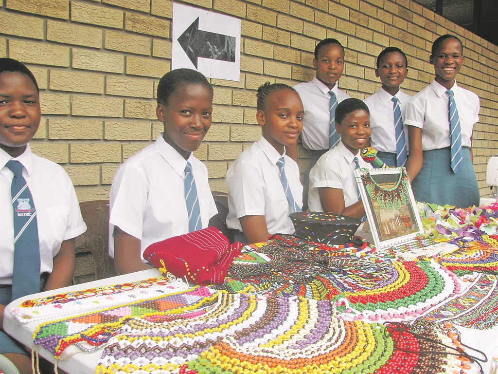 Kwanele and Sphelele, (second and third from left), sell beads.