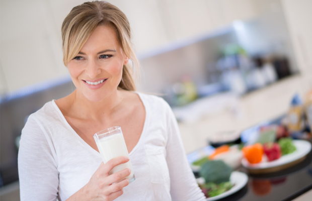 Woman drinking milk in kitchen