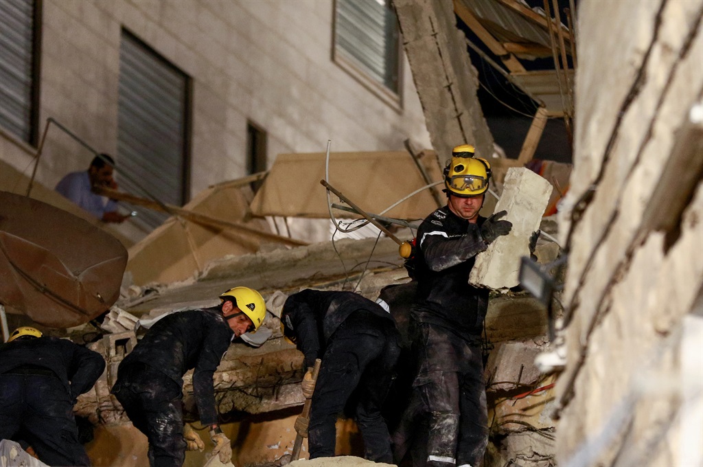 Jordanian rescue workers search for missing persons under the rubble of a four-storey residential building which collapsed in central Amman, on September 13, 2022.