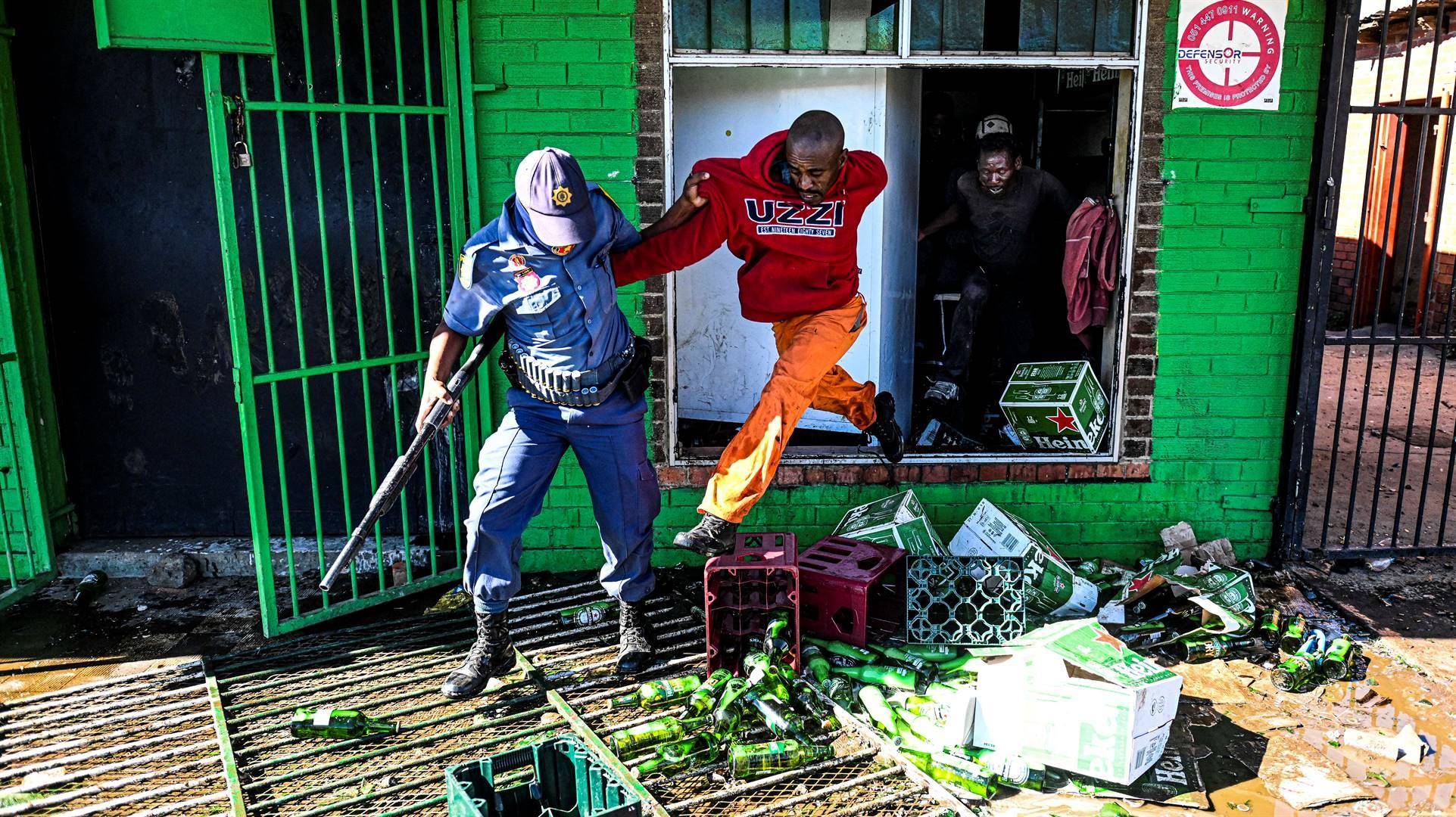 ’n Polisieman kry ’n plunderaar beet by ’n winkel in Eshowe.  Foto: Mlungisi Louw