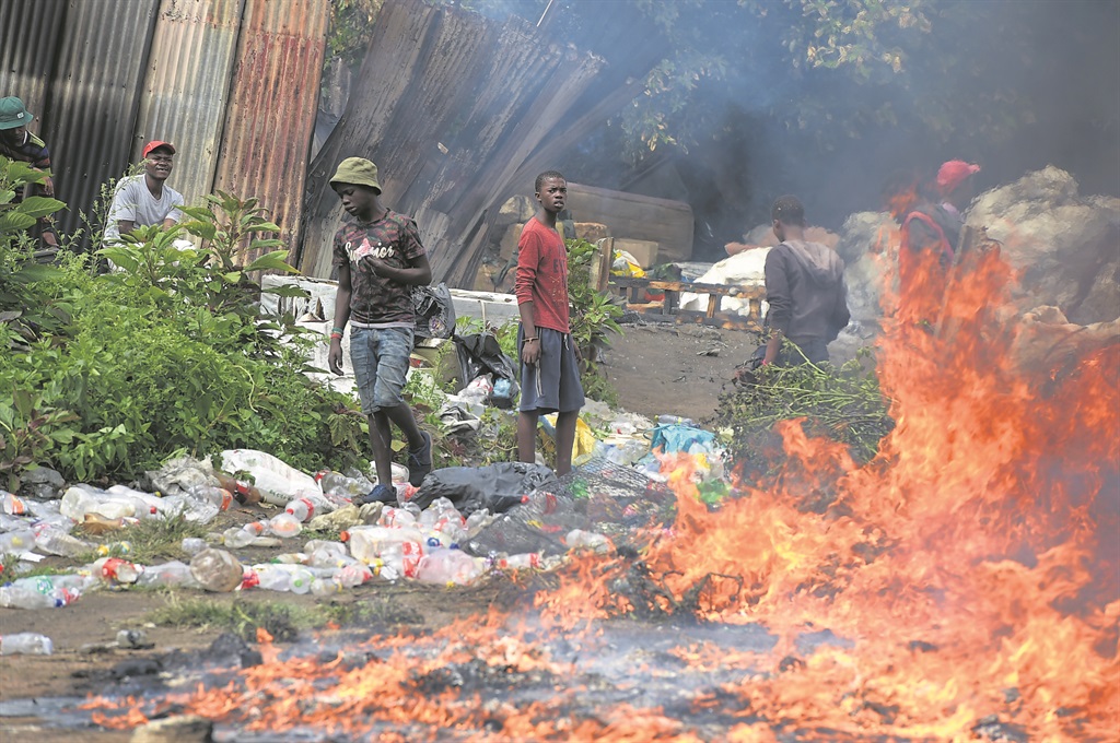 Collectors tried to salvage their goods from the flames.  Photo by    Lucky Nxumalo