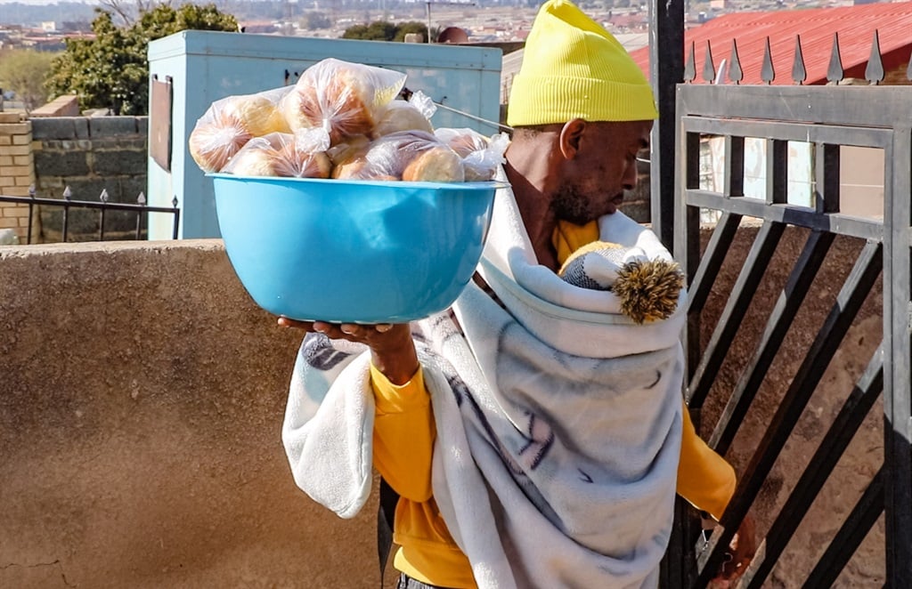 Mncube has been baking and selling biscuits since 2020 and carries his 10-month son to sell biscuits on the roadside or when he delivers orders to clients.