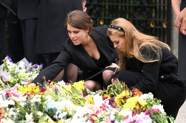 Eugenie and Beatrice looking at flowers left by mo