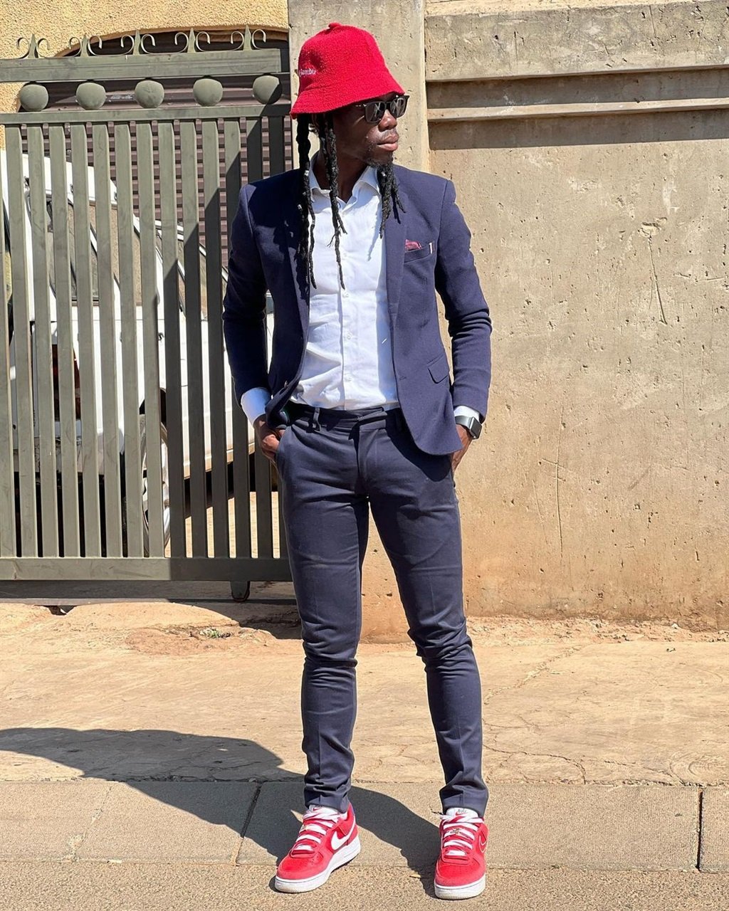 Yeye rocking a navy suit and some stand-out red pi