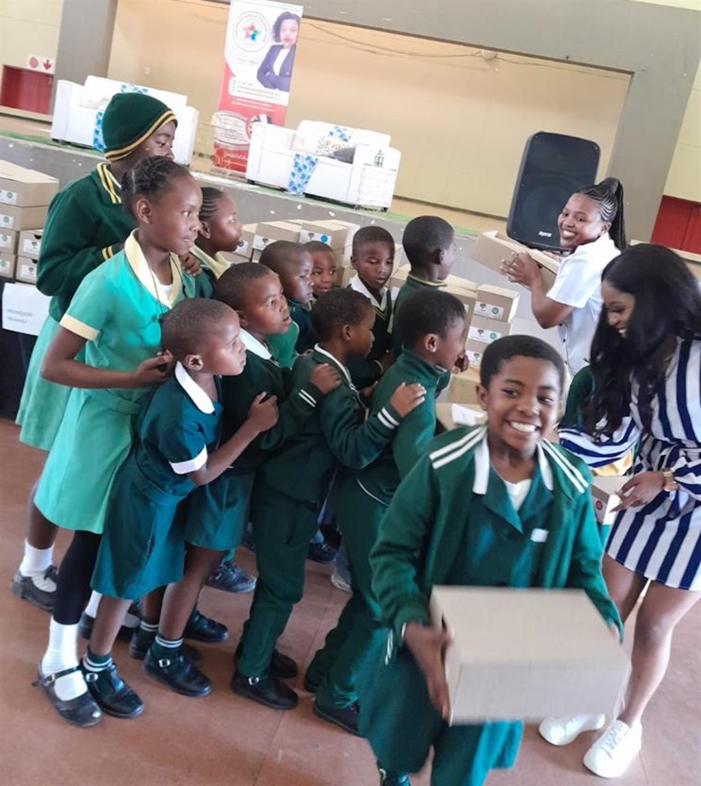 Zinhle Ndlovu, a registered nurse working in the medical intensive care unit at Netcare Kingsway Hospital, Amanzimtoti, gift young girls with shoes.  Photo: Supplied. 