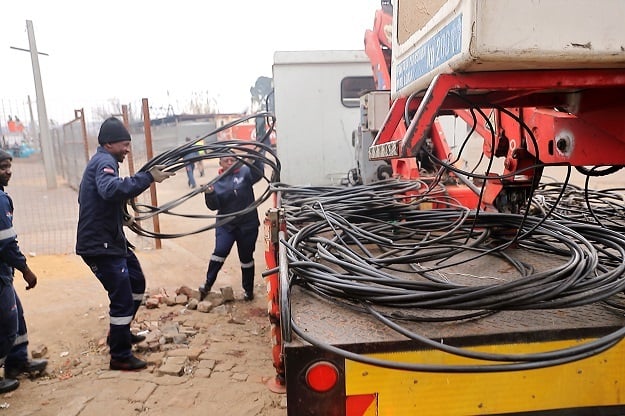 City Power workers collect bundles of illegal electricity collections in Kliptown. 