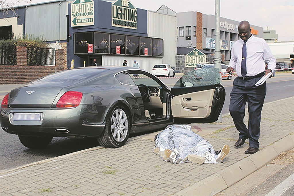 Ignatius ‘Igo’ Mpambani’s body lies next to the Bentley he was driving when he was shot in June last year.        Photo by Michael Butler/Sandton Chronicle
