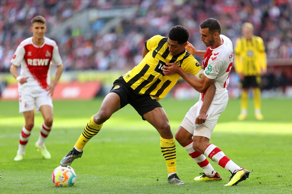 COLOGNE, GERMANY - OCTOBER 01: Jude Bellingham of Borussia Dortmund is challenged by Ellyes Skhiri of 1.FC Koeln during the Bundesliga match between 1. FC KÃ¶ln and Borussia Dortmund at RheinEnergieStadion on October 01, 2022 in Cologne, Germany. (Photo by Dean Mouhtaropoulos/Getty Images)