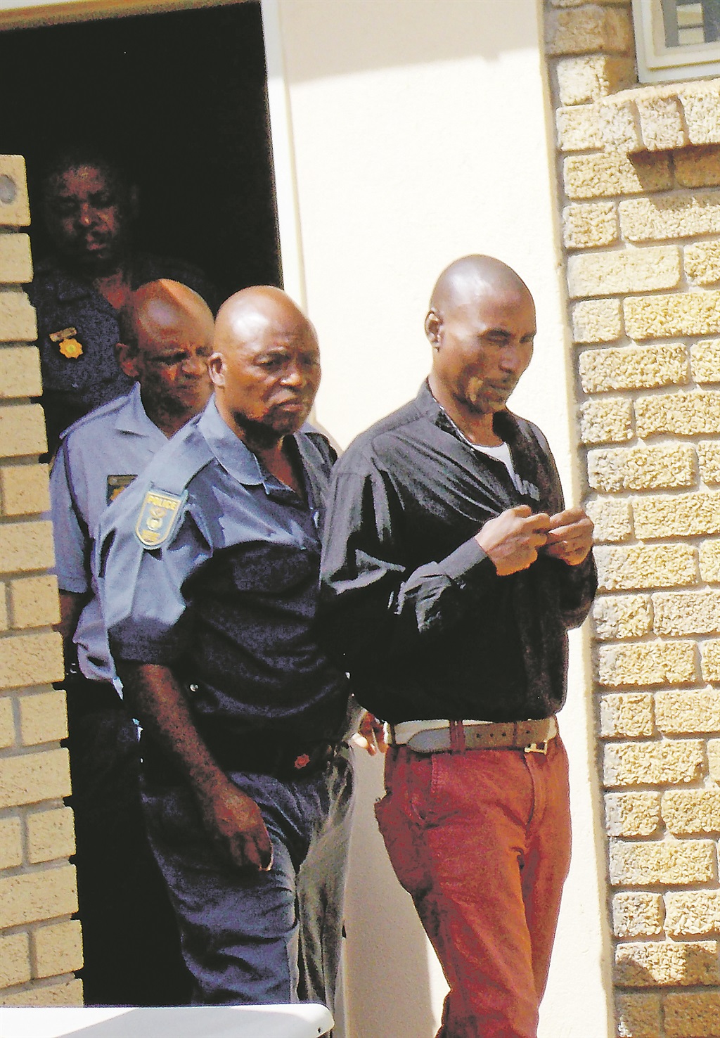 Cops escort Vusi Zulu to the holding cells.Photo by Tlangelani Khosa