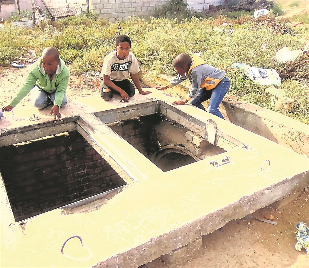 Young boys risk their lives daily playing next to the dangerous uncovered storm water drains in Motherwell kasi, Port Elizabeth.     Photo by Godfrey Sigwela