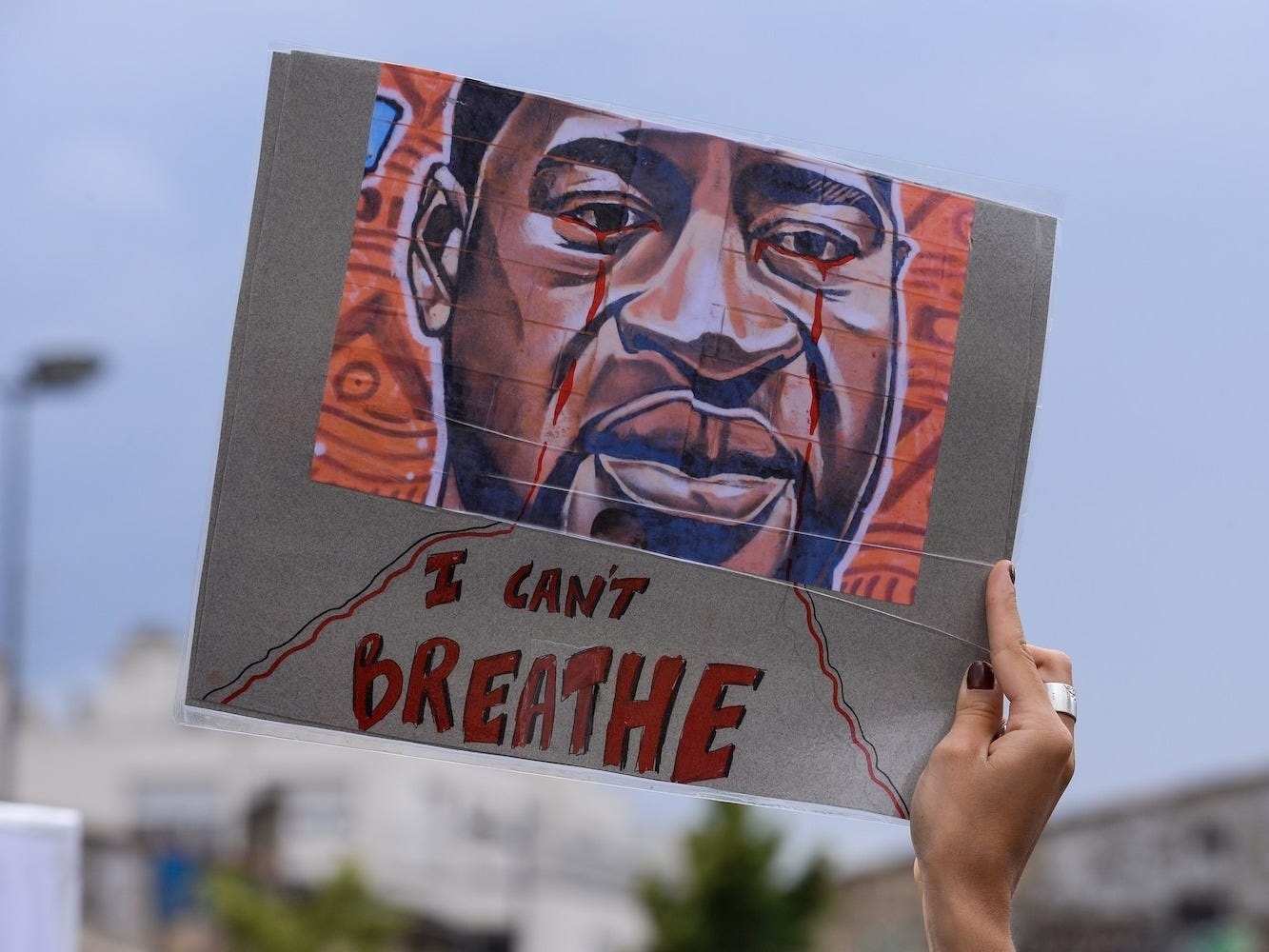 A woman holds a placard depicting George Floyd's face and reading "I can't breathe" in Bordeaux, France, on June 9, 2020 Nicolas Tucat/AFP via Getty Images