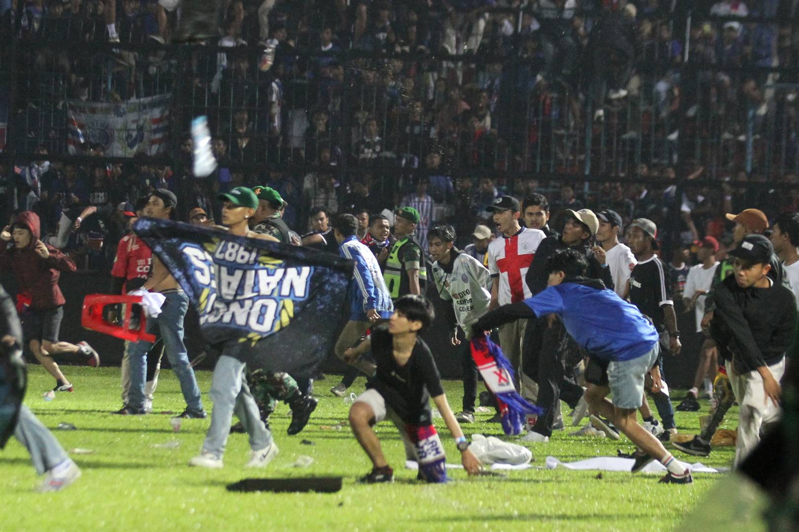 Sokkertoeskouers in Indonesië bestorm Saterdagaand die veld nadat hul span verloor het. Foto: Reuters