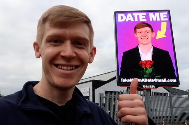 Ed photographed with his billboard.