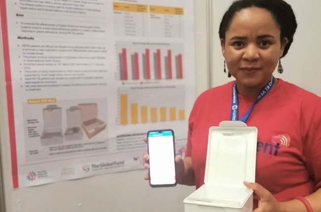 Nontobeko Mokone, study coordinator at the Aurum Institute showing off her poster and smart pill box at the SA TB Conference. 