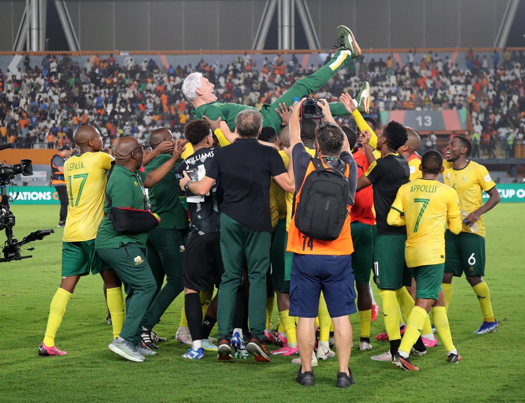 Bafana head coach Hugo Broos is tossed in the air by his jubilant players after South Africa secured a bronze medal at Afcon.