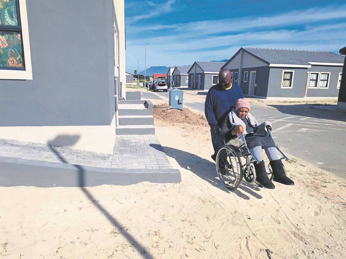 Neighbour Tori Kamle pushes gogo Nolufefe Ngcaza near her newly built RDP house in Gugulethu days before she passed away.