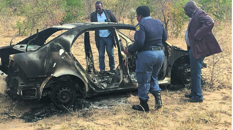 Cops at the scene where a vehicle was set alight by hijackers near Hluvukani Village.         Photo by Tlangelani Khosa