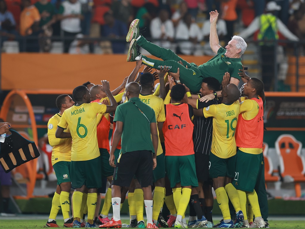 South African players celebrates with Hugo Henri Broos (Head Coach) of South Africa after winning the penalty shoot out of the TotalEnergies CAF Africa Cup of Nations, 3rd Place Playoff match between South Africa and Democratic Republic Of Congo at Stade Felix Houphouet Boigny on February 10, 2024 in Abidjan, Ivory Coast. 