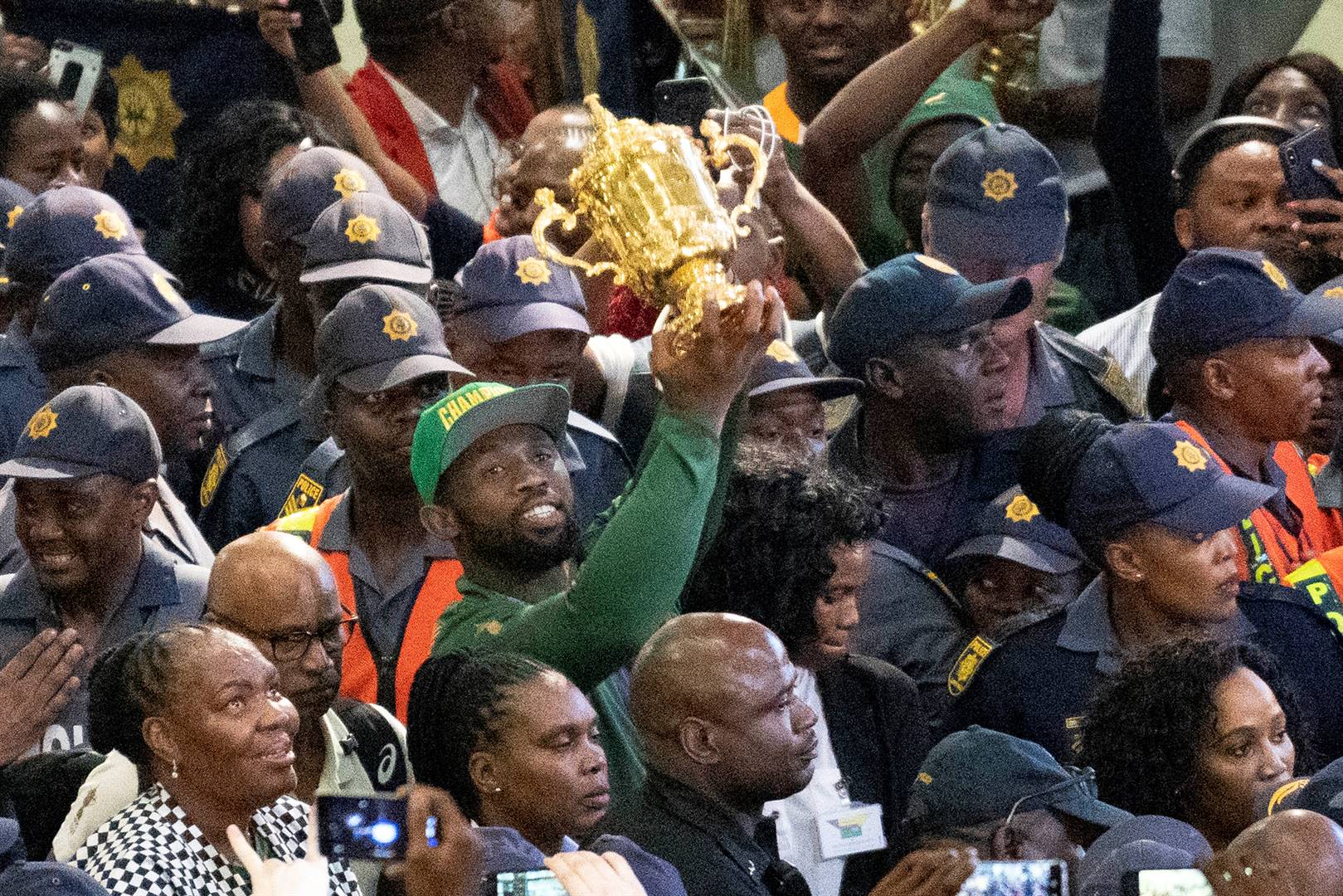 Siya Kolisi holds the Webb Ellis Cup as he is greeted by hundreds of fans upon his arrival at Johannesburg’s OR Tambo airport on Tuesday. South Africa defeated England 32-12 in the Rugby World Cup final on Saturday Picture: Jerome Delay/AP