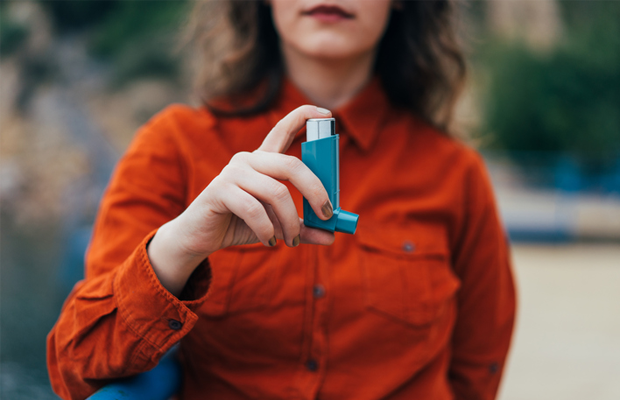 Woman holding asthma inhaler