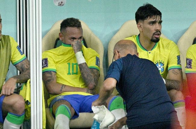Neymar on the bench with an injured right ankle. (Photo by Lionel Hahn/Getty Images)