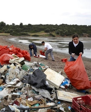 Volunteers gather bags with garbage during a trash collection at Kolovrechtis wetland near Halkida, Evia island. (Thanassis Stavrakis, AP)