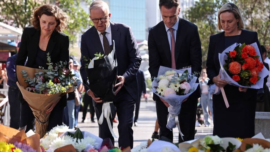 Australian Prime Minister Anthony Albanese (2nd L), New South Wales Premier Chris Minns (2nd R) and federal member of parliament Allegra Spender (L) leave flowers outside the Westfield Bondi Junction shopping mall in Sydney, the day after a 40-year-old knifeman with mental illness roamed the packed shopping centre killing six people and seriously wounding a dozen others. (David Gray/AFP)