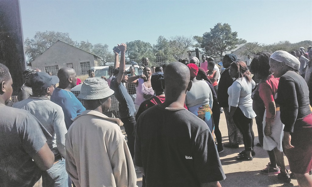 Groups of angry residents swore at each other outside the community hall in Utah Village.           Photo by Oris Mnisi