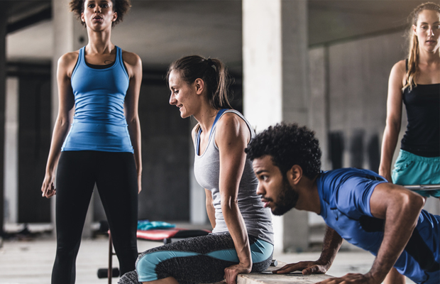 Men and women exercising in gym
