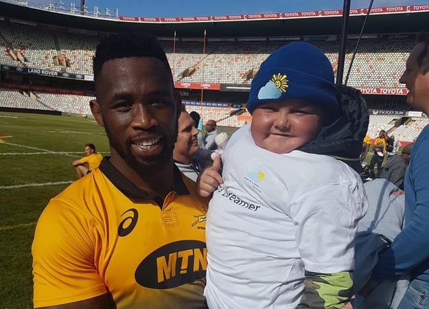 7-year-old Peet Pretorius beaming in the arms of Springbok captain Siya Kolisi on Friday.