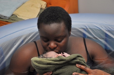 water birth mother kissing newborn
