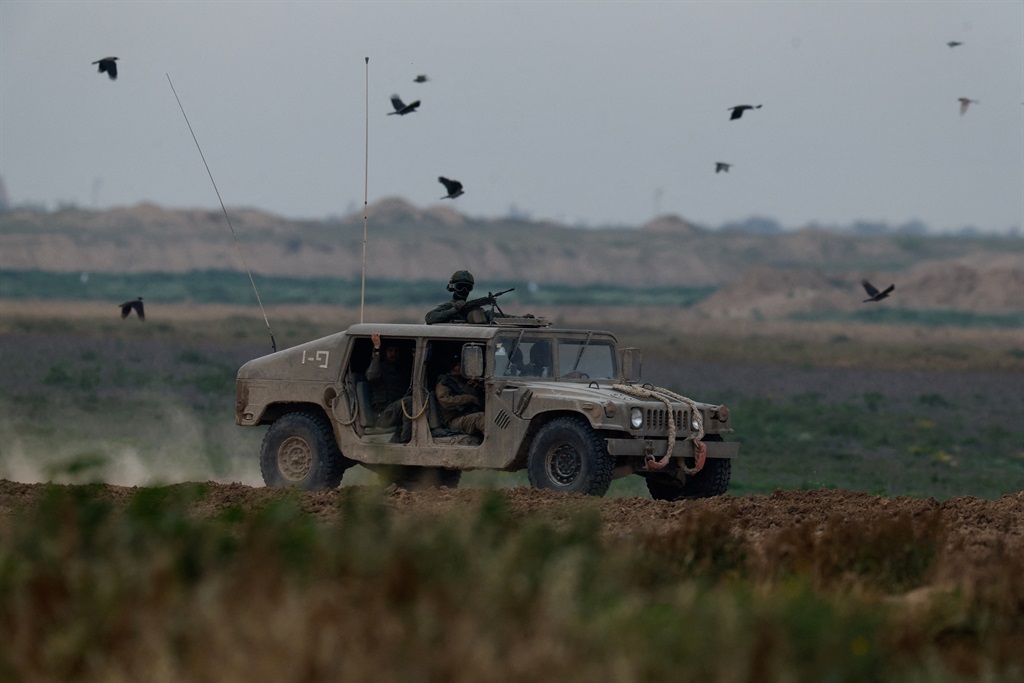 Israeli soldiers ride in a Humvee near the border 
