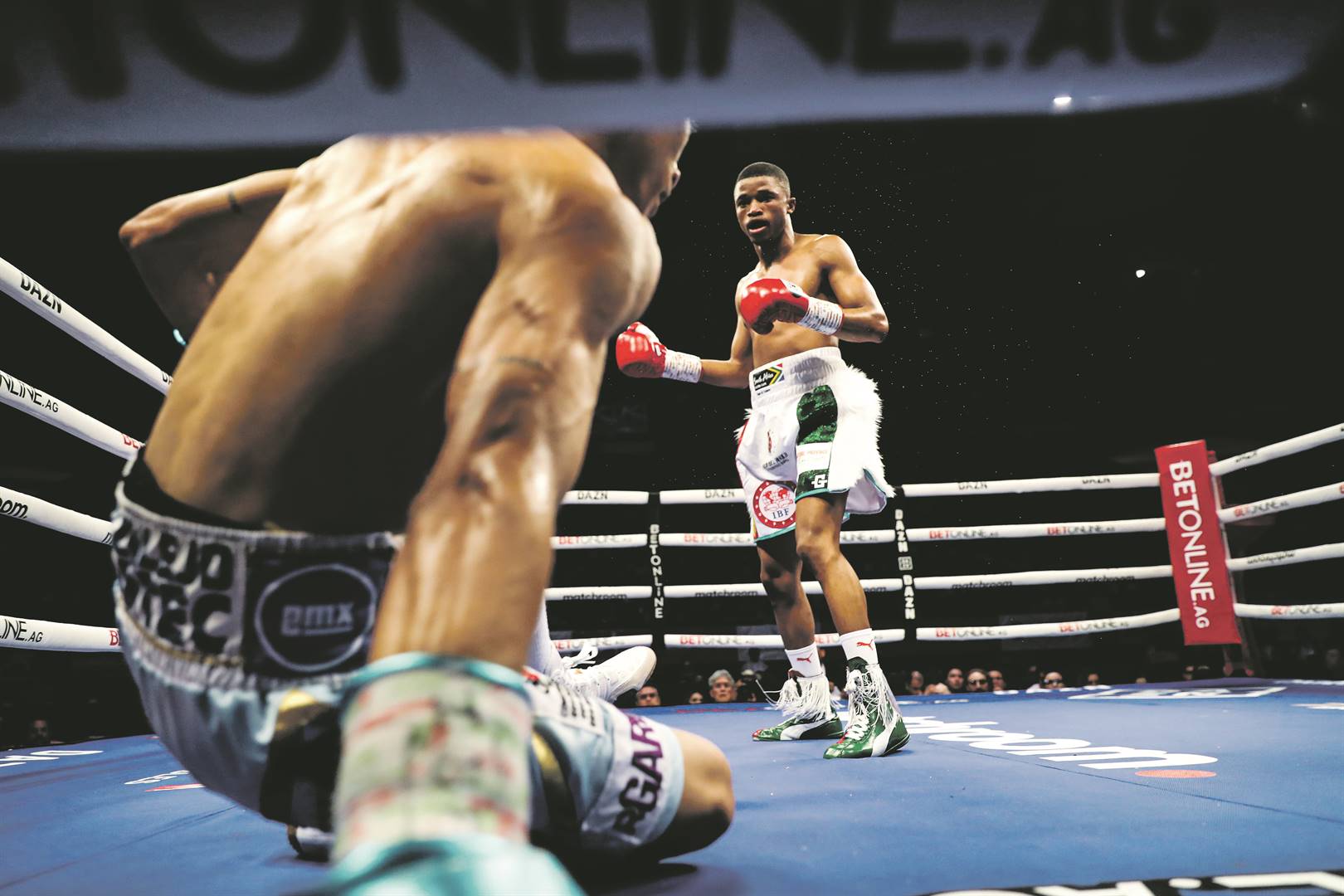 Sivenathi Nontshinga sends Hector Flores to the canvass during their IBF light flyweight world championship bout in September 2022