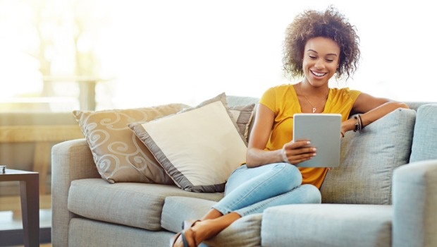 Woman sitting on a couch using her tablet. 