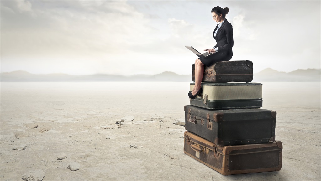 Businesswoman is sitting on the top of some luggagesPHOTO: 