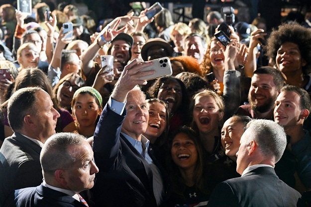 ABD Başkanı Joe Biden (C) ile bir selfie için poz veriyor