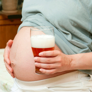 Pregnant woman with a glass of alcohol