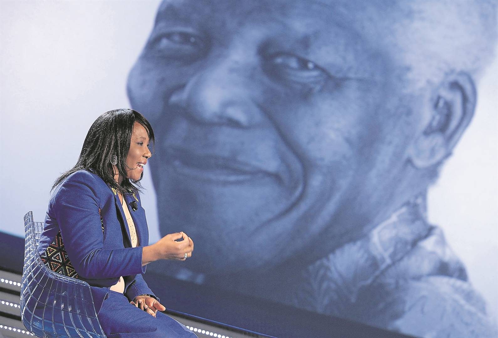 Makaziwe Mandela sits in front of a portrait of her father, Nelson Mandela. Photo: Getty Images