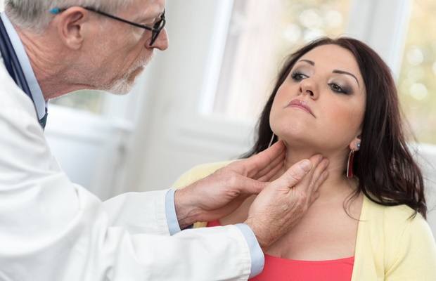 doctor examining patient for thyroid 
